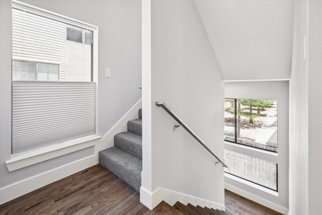 stairs featuring dark hardwood / wood-style floors and lofted ceiling