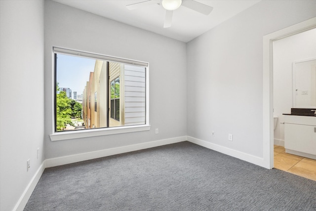 carpeted spare room featuring ceiling fan