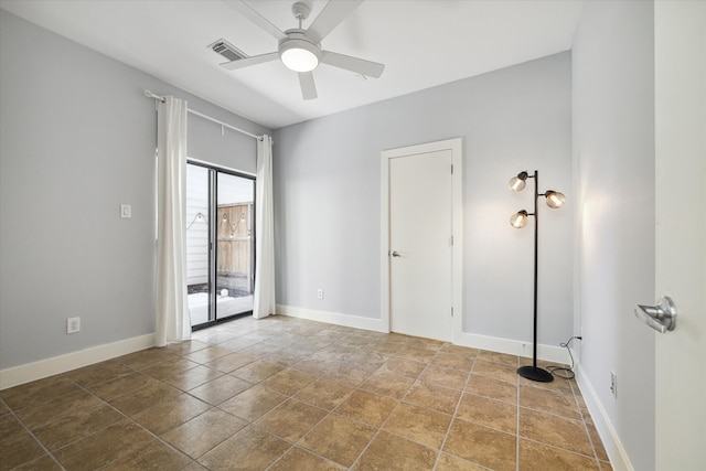 tiled spare room featuring ceiling fan