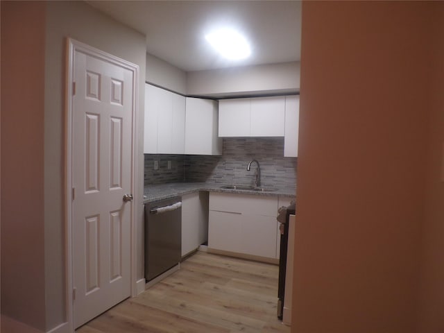 kitchen featuring appliances with stainless steel finishes, light stone countertops, sink, white cabinets, and tasteful backsplash