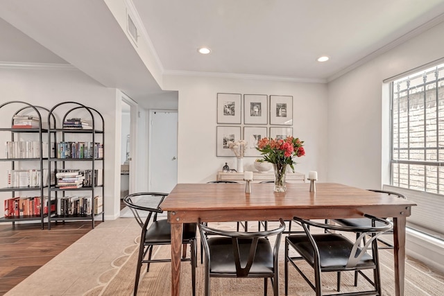 dining room with crown molding and hardwood / wood-style flooring