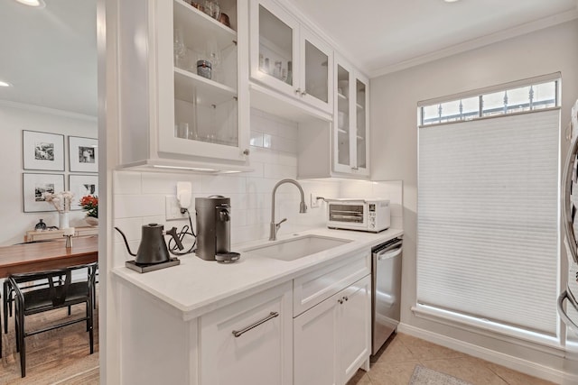 kitchen with white cabinetry, sink, tasteful backsplash, stainless steel dishwasher, and light tile patterned flooring