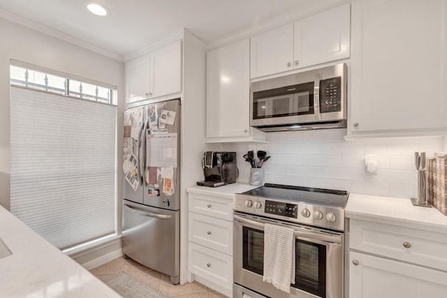 kitchen featuring white cabinets, appliances with stainless steel finishes, backsplash, and light tile patterned flooring