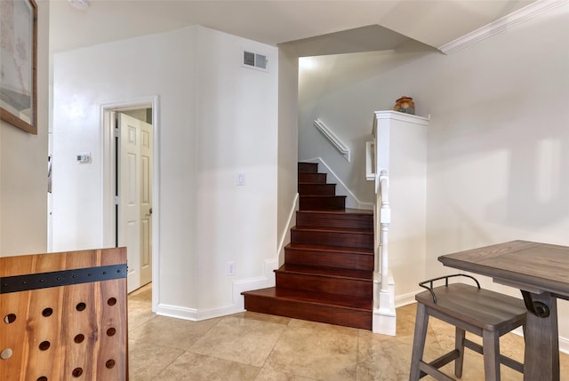 staircase featuring tile patterned floors and crown molding