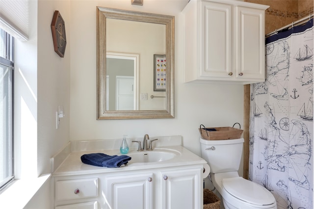 bathroom featuring vanity, toilet, and walk in shower