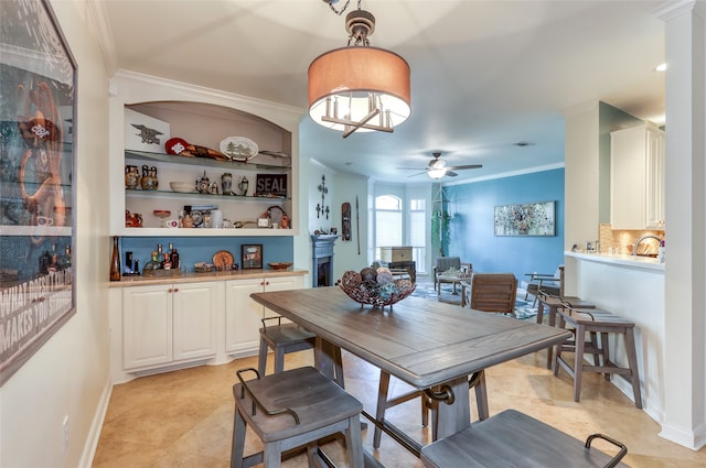 dining space featuring ceiling fan, built in features, and crown molding