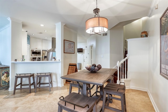 dining space featuring ornate columns and ornamental molding