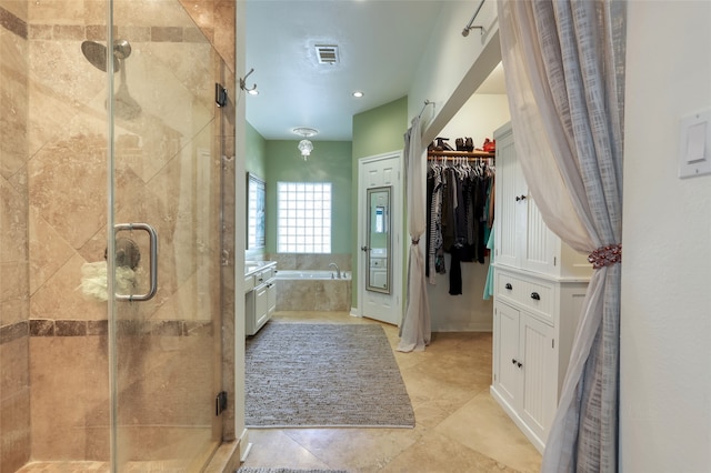 bathroom featuring tile patterned floors and separate shower and tub