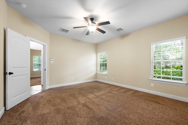 carpeted spare room with a healthy amount of sunlight and ceiling fan