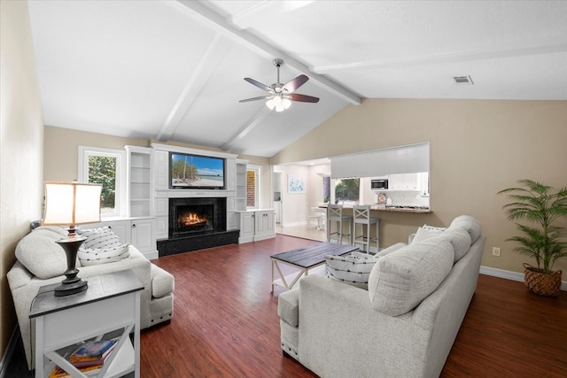 living room featuring dark hardwood / wood-style floors, lofted ceiling with beams, a fireplace, and ceiling fan