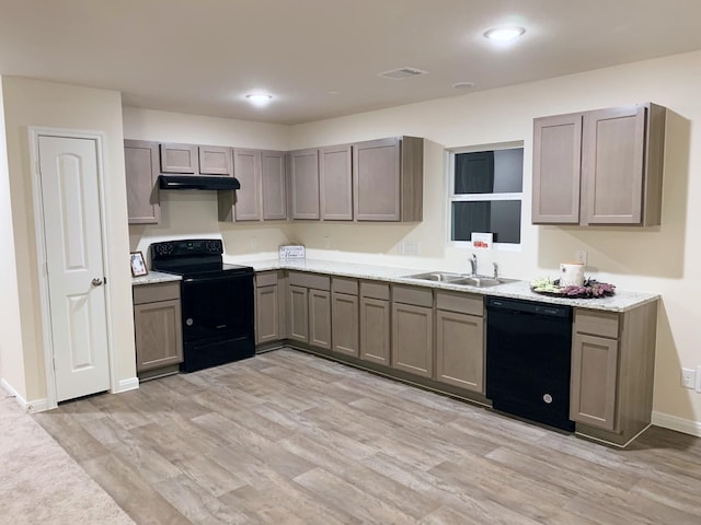 kitchen with sink, light hardwood / wood-style flooring, gray cabinetry, and black appliances