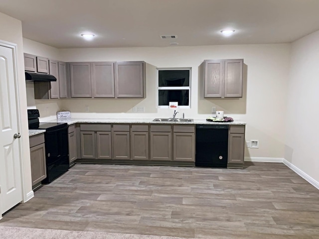 kitchen with light wood-type flooring, sink, gray cabinetry, and black appliances