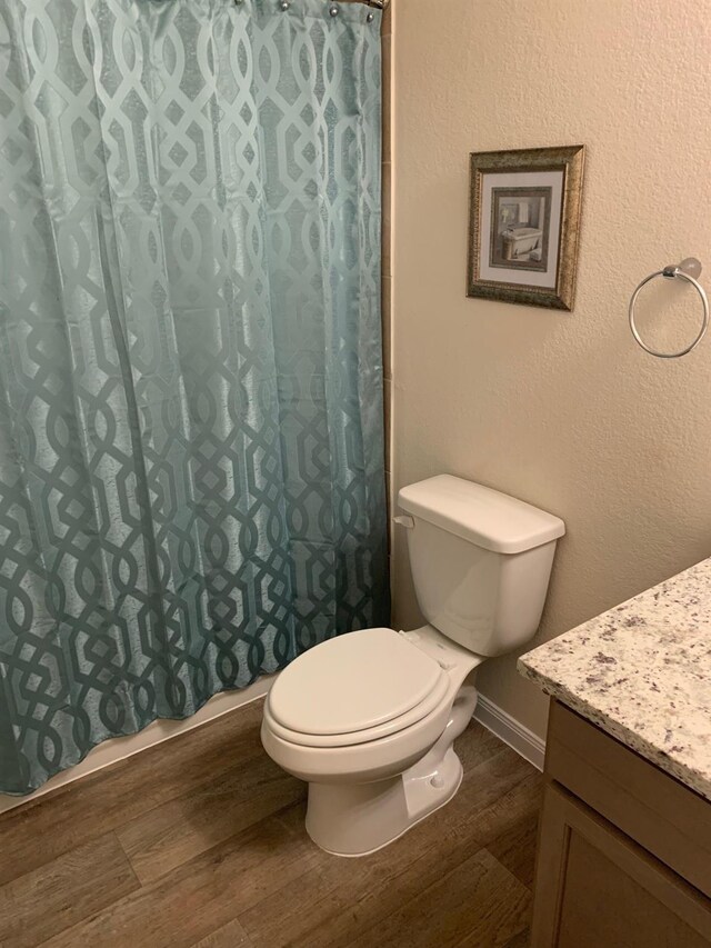 bathroom with a shower with curtain, toilet, vanity, and hardwood / wood-style flooring