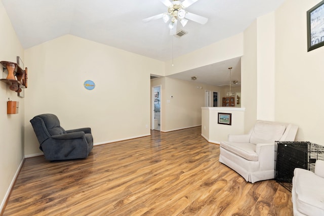 living area featuring ceiling fan, wood-type flooring, and vaulted ceiling