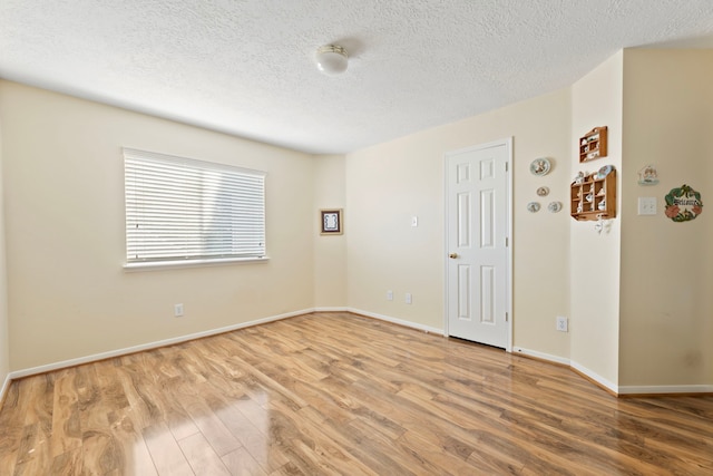 empty room featuring hardwood / wood-style flooring and a textured ceiling