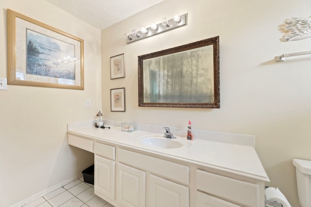 bathroom with toilet, a textured ceiling, tile patterned flooring, and vanity