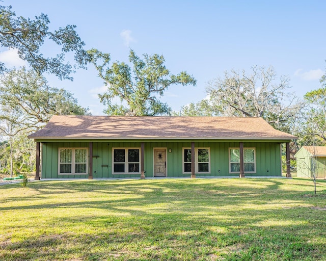 ranch-style home with board and batten siding and a front lawn