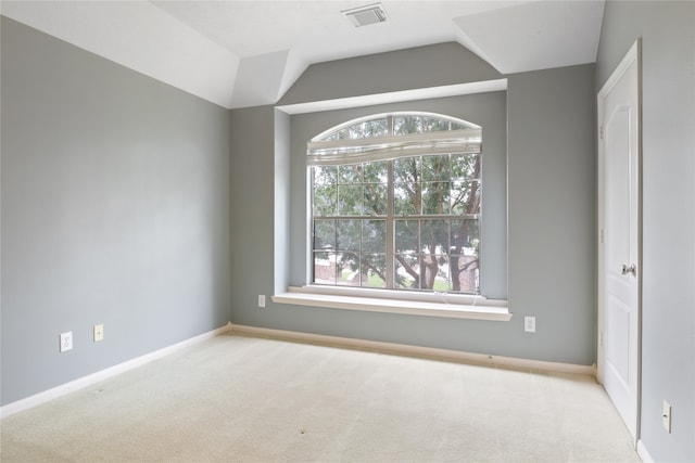 unfurnished room featuring light colored carpet, a healthy amount of sunlight, and vaulted ceiling