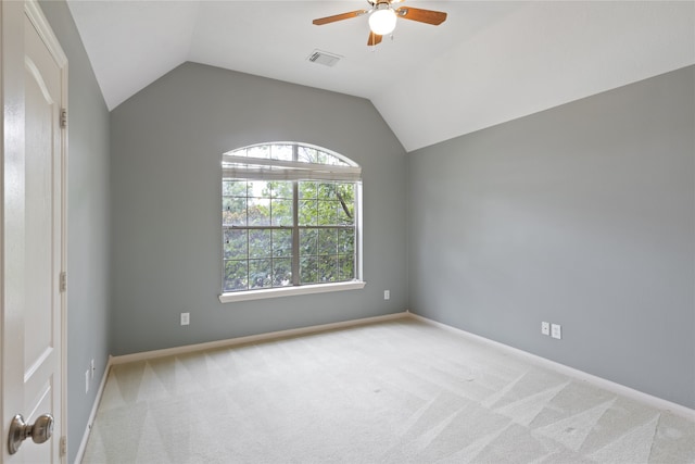 spare room with light carpet, plenty of natural light, and lofted ceiling