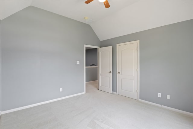 unfurnished bedroom with ceiling fan, light colored carpet, and vaulted ceiling