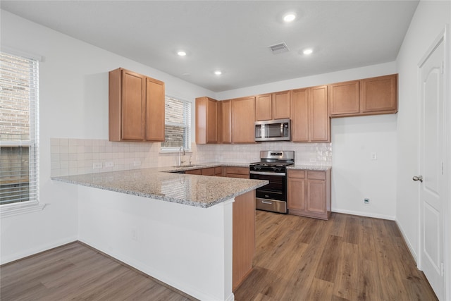 kitchen with sink, stainless steel appliances, light hardwood / wood-style flooring, and plenty of natural light