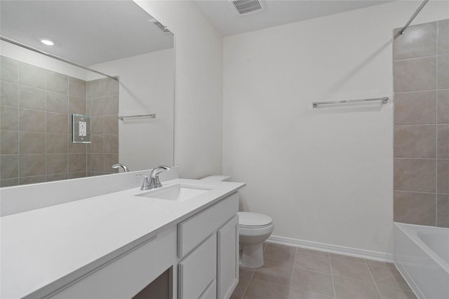 full bathroom featuring tile patterned floors, vanity, tiled shower / bath combo, and toilet