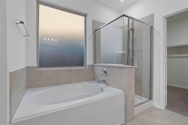 bathroom with tile patterned flooring and separate shower and tub