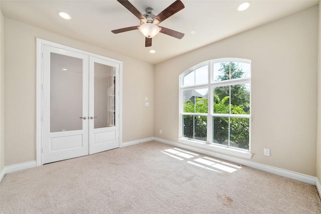 carpeted spare room with french doors and ceiling fan