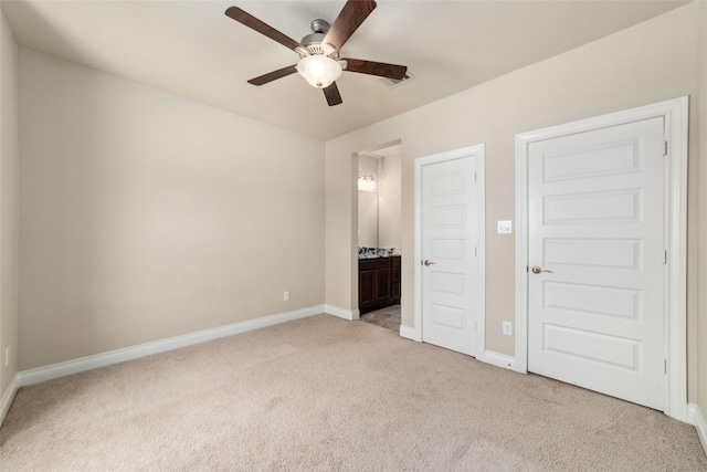 unfurnished bedroom with connected bathroom, light colored carpet, and ceiling fan