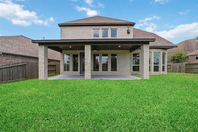 back of property with a lawn and a patio