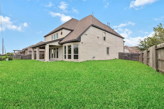 rear view of property featuring a yard