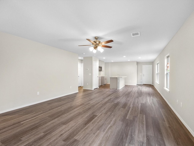 unfurnished living room featuring dark hardwood / wood-style floors and ceiling fan