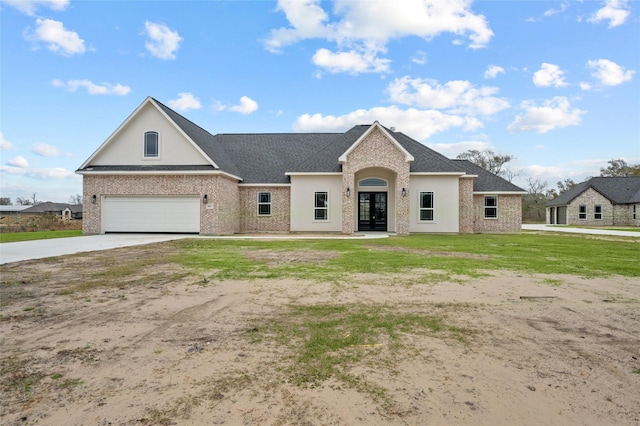 view of front of property featuring french doors, a front yard, and a garage