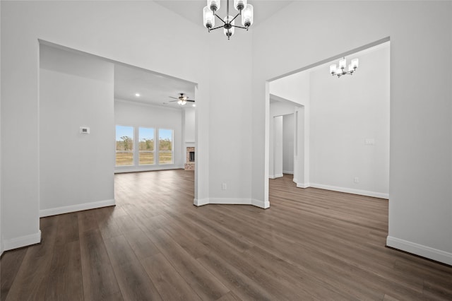 interior space featuring ceiling fan with notable chandelier and dark wood-type flooring