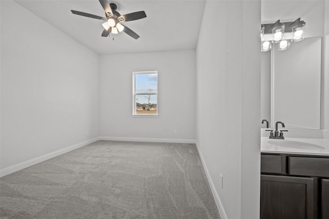 spare room with sink, ceiling fan, and carpet