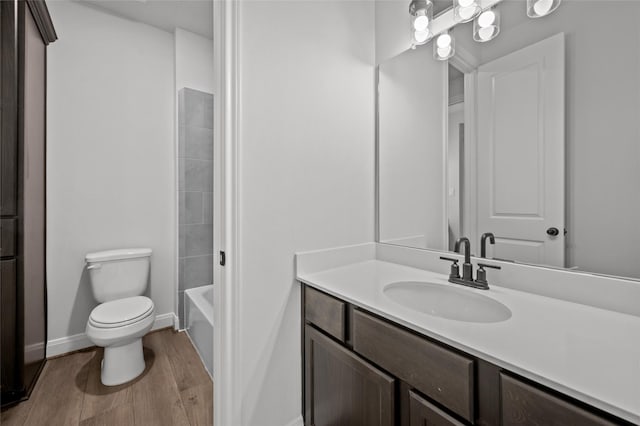 full bathroom with toilet, wood-type flooring, vanity, and bathing tub / shower combination