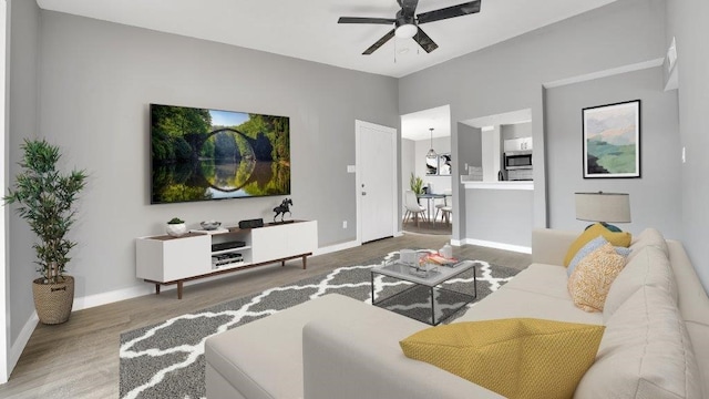 living room with hardwood / wood-style floors and ceiling fan