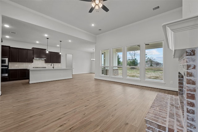 living room featuring a fireplace, ceiling fan, light hardwood / wood-style floors, and crown molding