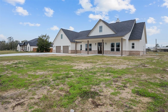 modern farmhouse featuring covered porch and a garage