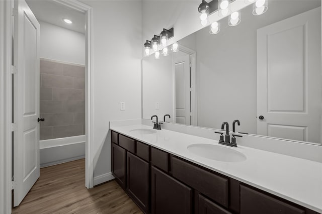 bathroom featuring hardwood / wood-style flooring,  shower combination, and vanity