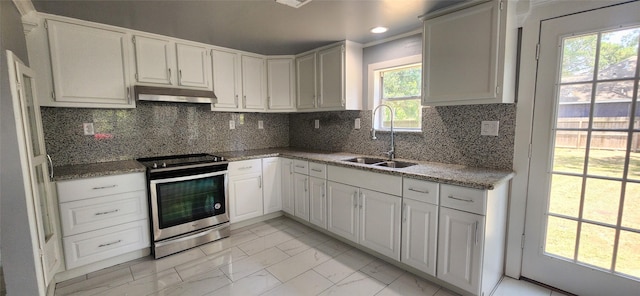 kitchen with backsplash, stainless steel electric range oven, sink, stone counters, and white cabinetry