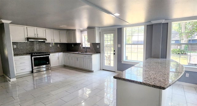 kitchen featuring stainless steel range, white cabinets, and plenty of natural light