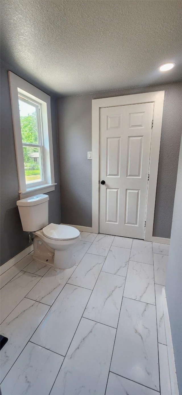 bathroom featuring a textured ceiling and toilet