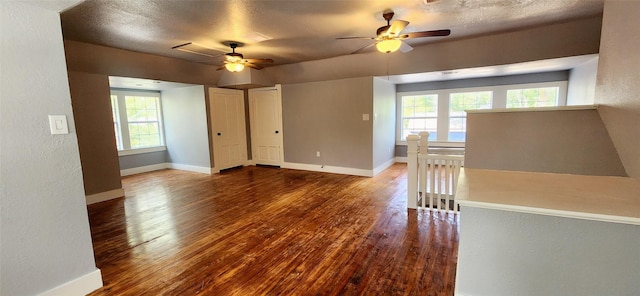 empty room featuring hardwood / wood-style flooring, ceiling fan, a healthy amount of sunlight, and a textured ceiling