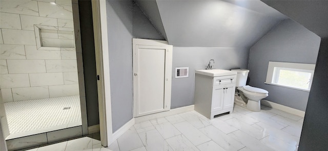 bathroom with toilet, vanity, lofted ceiling, and tiled shower