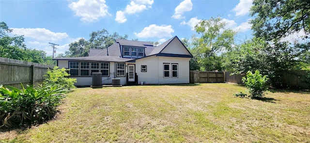 rear view of property with a lawn and central air condition unit