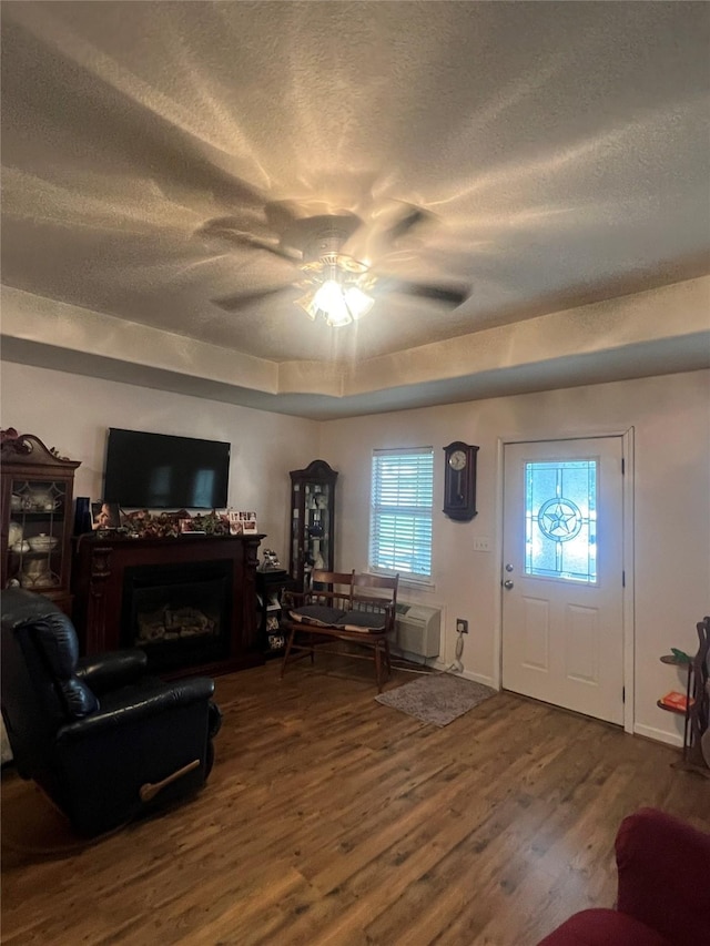 living room with ceiling fan, wood-type flooring, and a textured ceiling