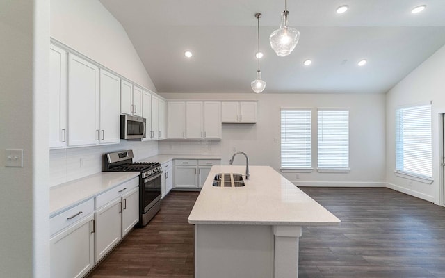 kitchen with lofted ceiling, a kitchen island with sink, sink, white cabinetry, and stainless steel appliances