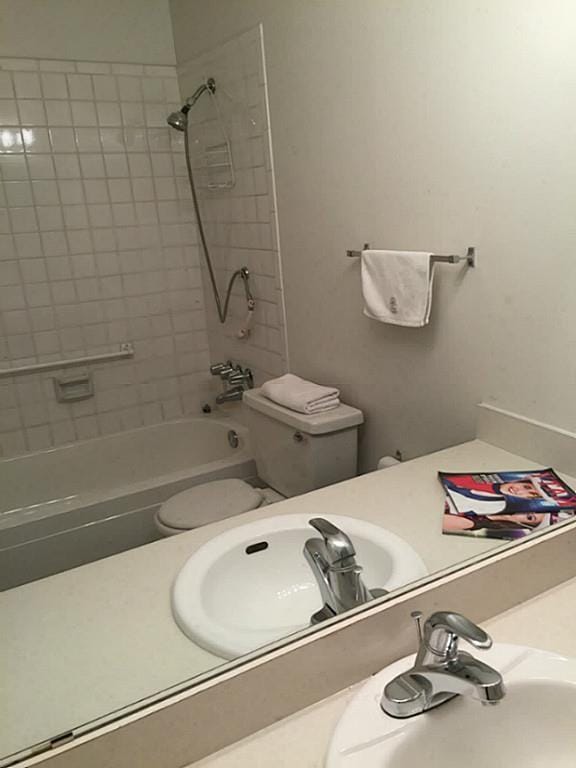 full bathroom with toilet, tiled shower / bath, and sink