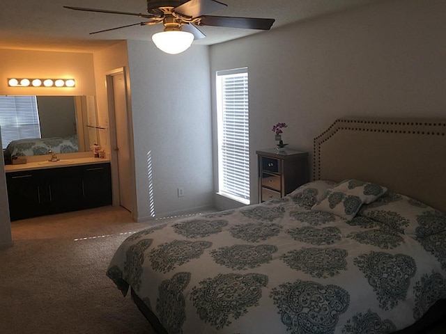 bedroom featuring ensuite bathroom, ceiling fan, sink, and light carpet